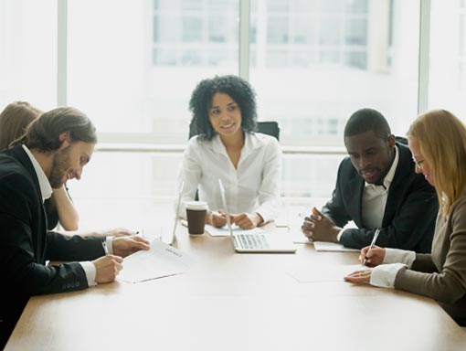 five people meeting around conference table