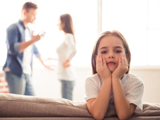 Parentings Fighting in Background with Child Hands on Face