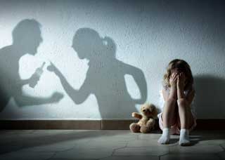 law-packages-dvro-child-floor child on floor with teddybear with shadow of parents fighting in background