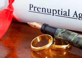 law-packages-ppna-rings prenuptial agreement with pen and two wedding rings on a table